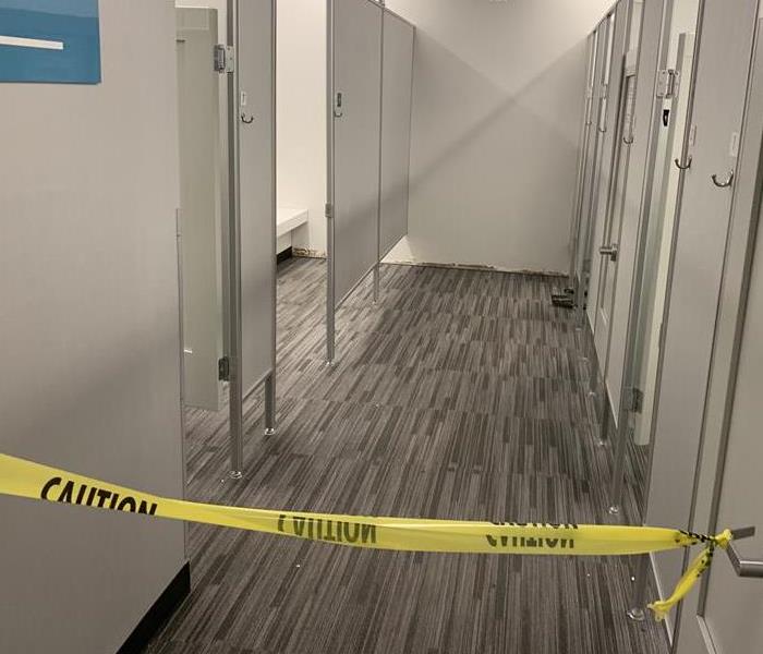 Hallway with grey carpet and yellow caution tape. 
