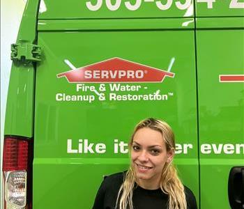Woman smiling in front of Servpro van