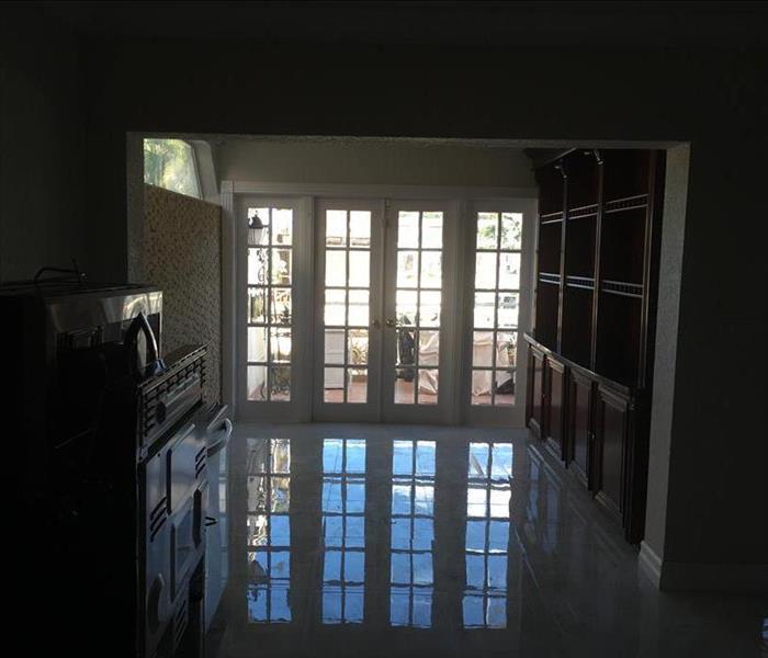 Room with windows and water on the floor. 