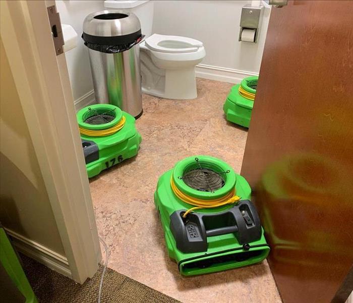 Bathroom with green air movers on the ground.