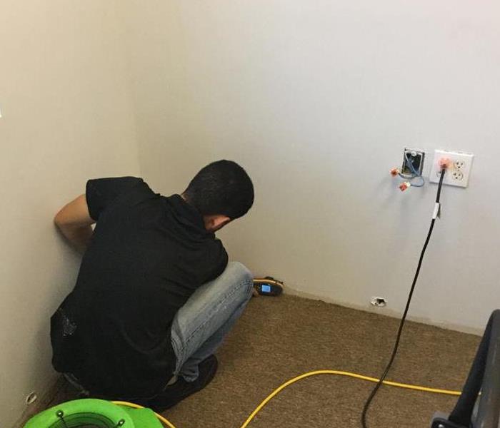 Man measuring moisture in a wall.