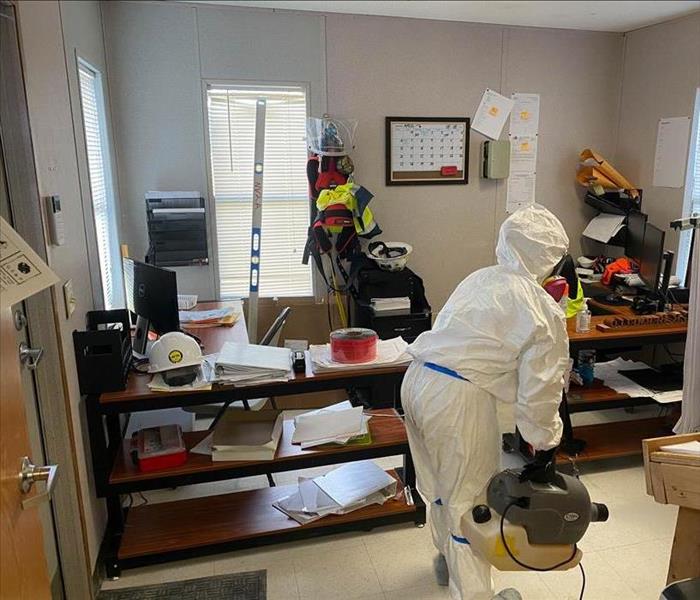 Employee in PPE inside an office.
