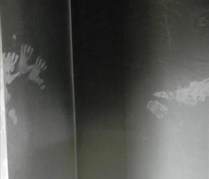 handprints on a wall with soot damage after a fire
