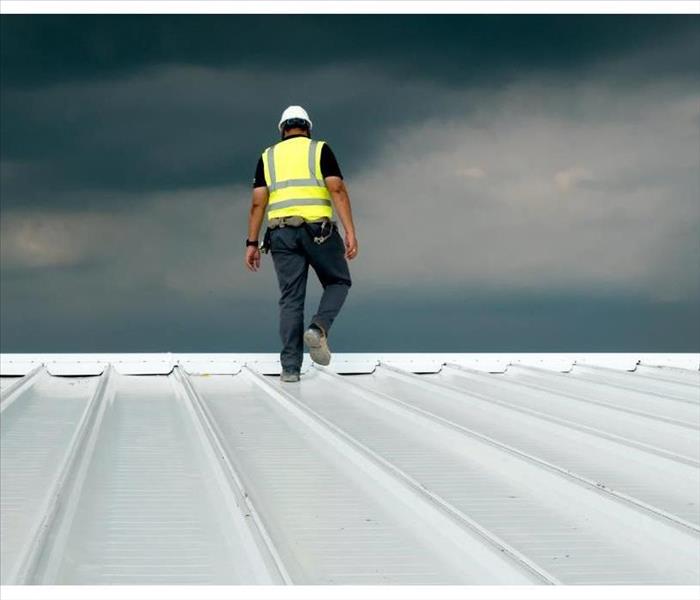 Construction engineer wearing safety uniform inspection metal roofing work for roof industrial concept