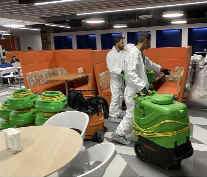 SERVPRO technicians with drying equipment in a commercial building
