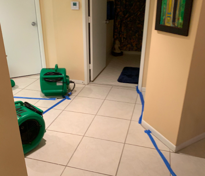 White tiled hallways with green air movers. 
